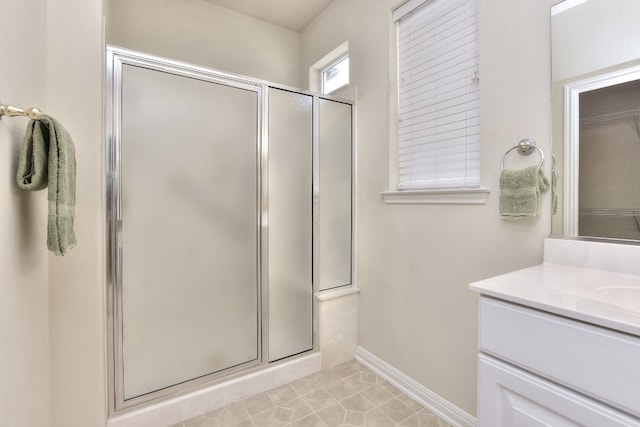 bathroom with tile patterned floors, walk in shower, and vanity