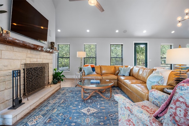 living room with ceiling fan, a fireplace, vaulted ceiling, and hardwood / wood-style flooring