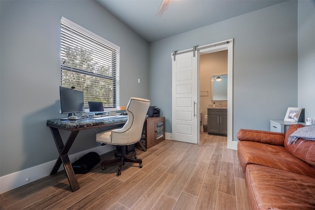 office area featuring light hardwood / wood-style flooring and a barn door