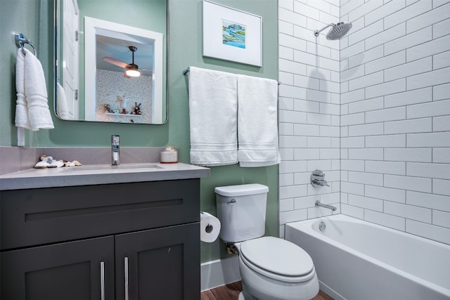 full bathroom featuring hardwood / wood-style floors, ceiling fan, toilet, vanity, and tiled shower / bath combo