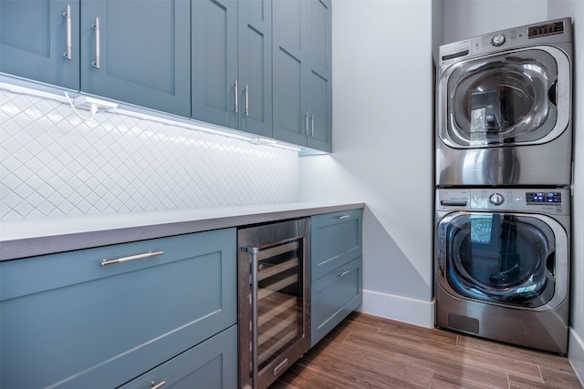 laundry area with cabinets, wine cooler, dark hardwood / wood-style flooring, and stacked washer and clothes dryer