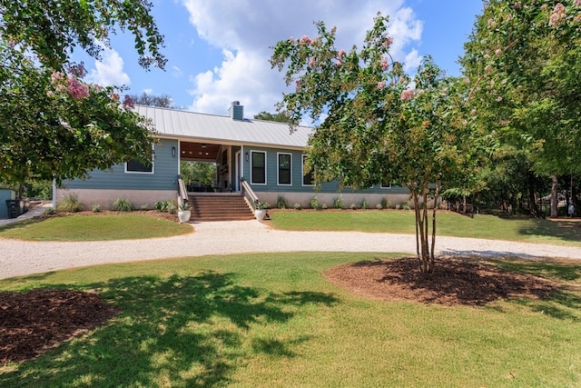 ranch-style house featuring metal roof, a chimney, and a front lawn