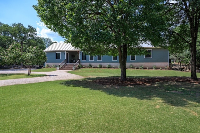 view of front of house with a front yard, a standing seam roof, and metal roof