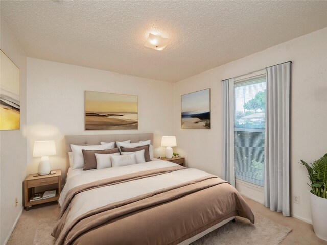 bedroom featuring a textured ceiling and light carpet