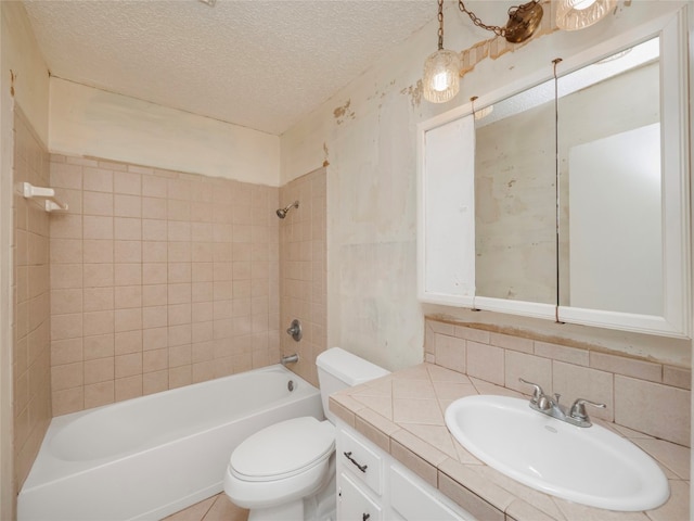 full bathroom with a textured ceiling, toilet, decorative backsplash, tiled shower / bath, and vanity