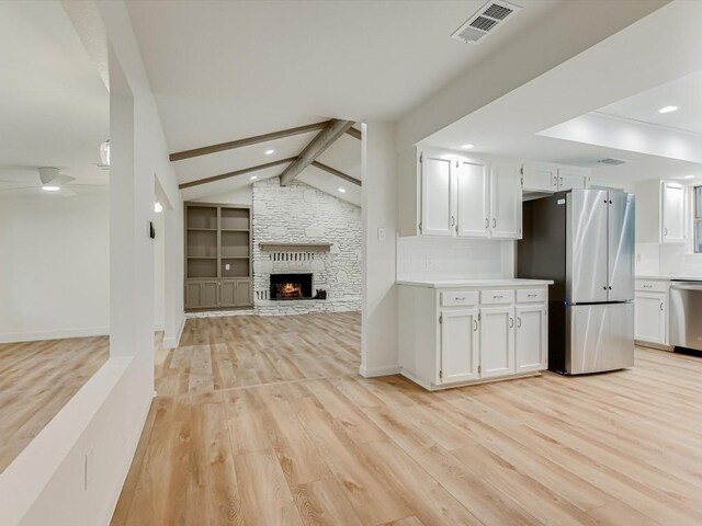 653 Leisure Ln, Cedar Creek, TX 78612 - kitchen featuring stainless steel appliances, light wood-style floors, open floor plan, white cabinets, and recessed lighting