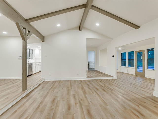 unfurnished living room with light wood-type flooring, sink, and lofted ceiling with beams