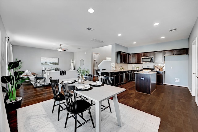 dining space with sink, ceiling fan, and dark wood-type flooring