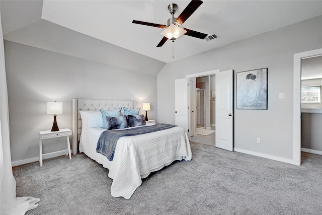 bedroom featuring ceiling fan, ensuite bath, lofted ceiling, and carpet flooring