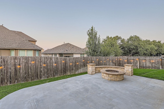 patio terrace at dusk featuring a fire pit