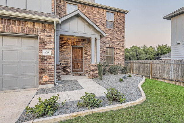 exterior entry at dusk featuring a garage