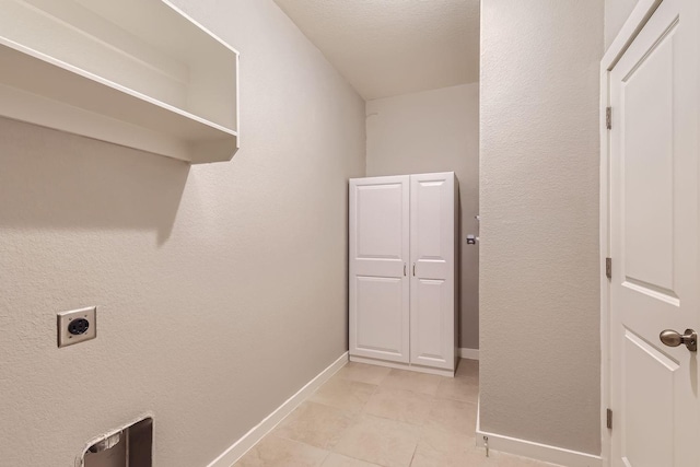 clothes washing area featuring hookup for an electric dryer and light tile patterned flooring