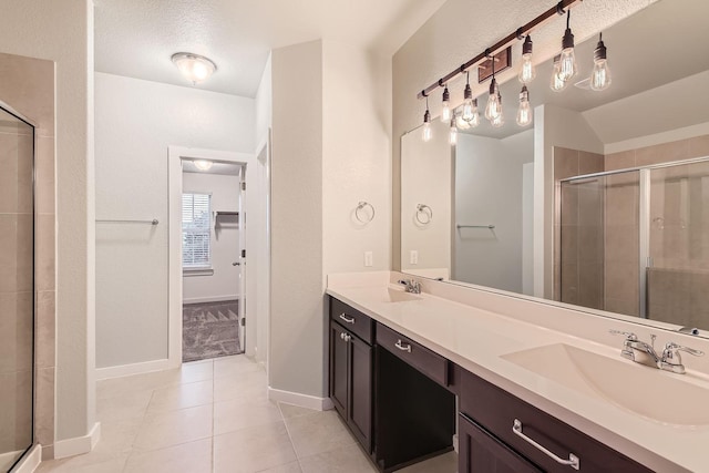 bathroom with vanity, walk in shower, tile patterned floors, and a textured ceiling