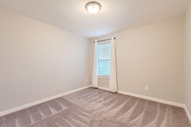 empty room featuring a textured ceiling and carpet flooring