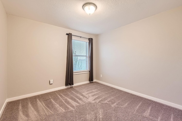 spare room featuring carpet and a textured ceiling