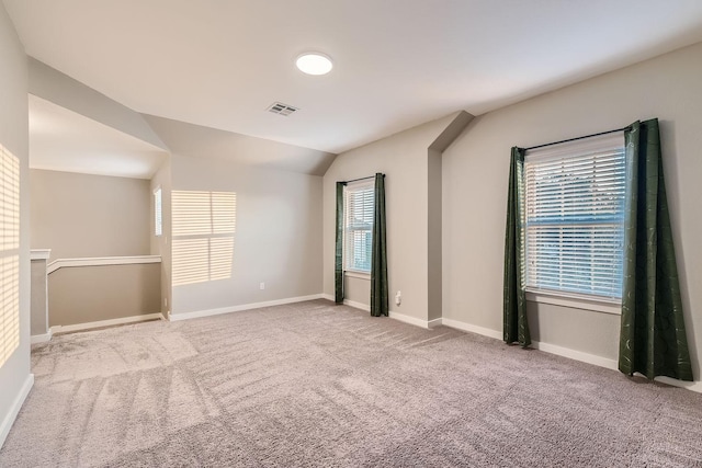 empty room with light colored carpet and vaulted ceiling