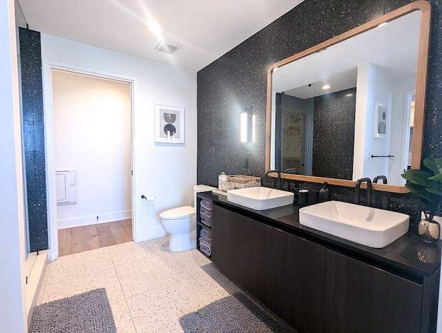 bathroom with hardwood / wood-style floors, a shower with shower door, dual vanity, and toilet