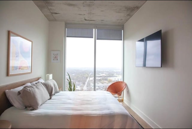 48 E Ave Unit 2405, Austin, TX 78701 - bedroom with floor to ceiling windows and baseboards
