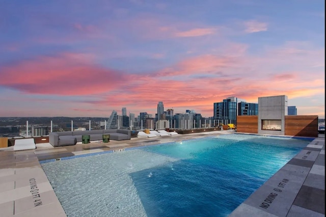 pool at dusk featuring pool water feature