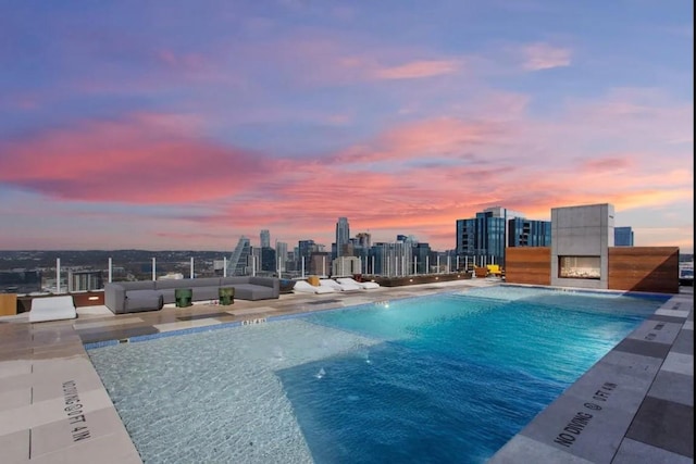 48 E Ave Unit 2405, Austin, TX 78701 - pool at dusk with a community pool, a skyline view, a patio, and an outdoor hangout area