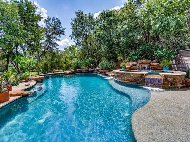 view of pool featuring pool water feature and an in ground hot tub