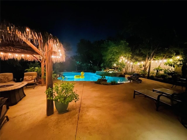 pool at night with a patio area