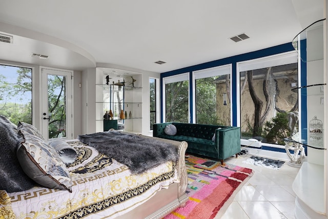 tiled bedroom featuring multiple windows and access to outside
