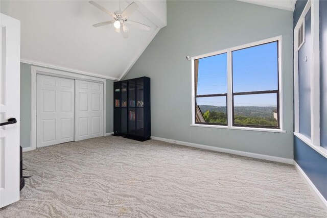 unfurnished bedroom with lofted ceiling, light colored carpet, a closet, and ceiling fan