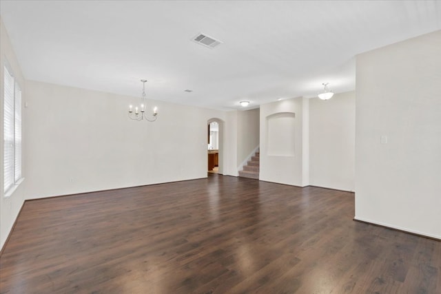 unfurnished room featuring dark wood-type flooring and a chandelier