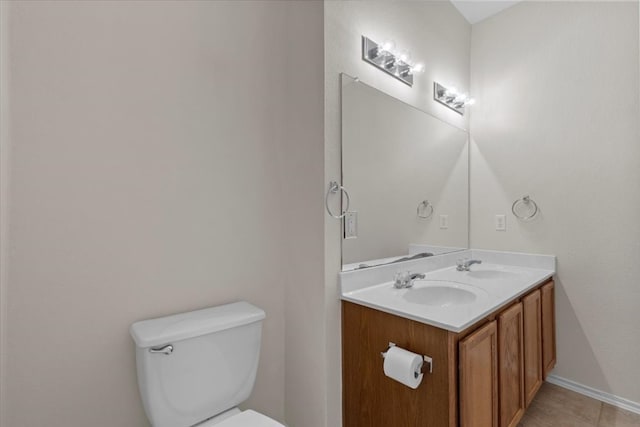 bathroom with toilet, vanity, and tile patterned flooring