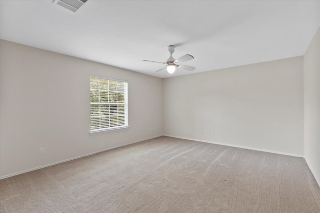 carpeted spare room featuring ceiling fan