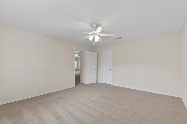 spare room featuring ceiling fan and light carpet