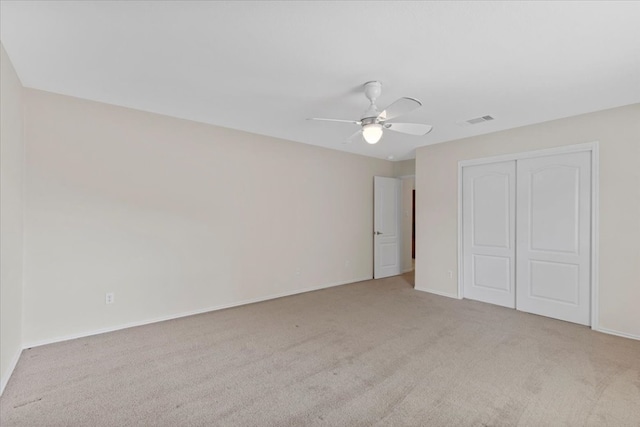 unfurnished bedroom with ceiling fan, carpet flooring, and a closet