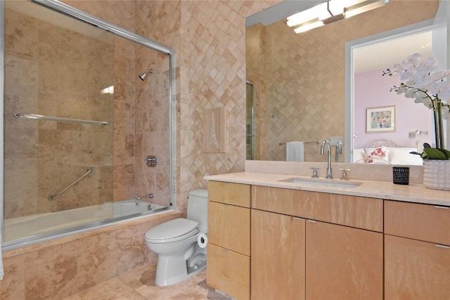 bathroom with toilet, tiled shower / bath combo, vanity, and tile patterned flooring