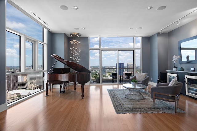 living area with a wealth of natural light, hardwood / wood-style floors, and floor to ceiling windows