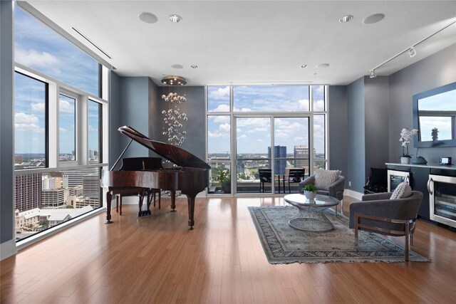 sitting room with expansive windows, beverage cooler, a view of city, and healthy amount of natural light