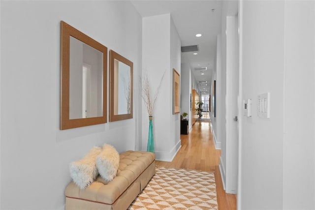 hall with light wood-style floors, recessed lighting, and baseboards