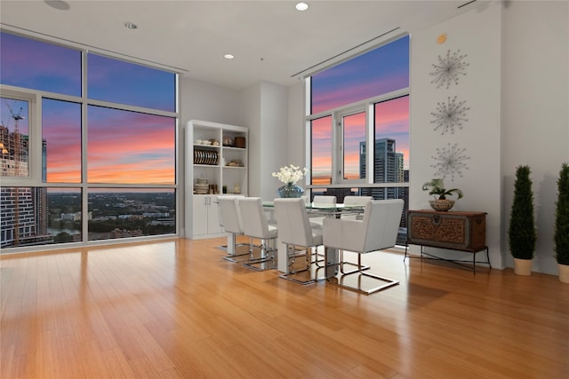 dining area with light hardwood / wood-style floors and a wall of windows