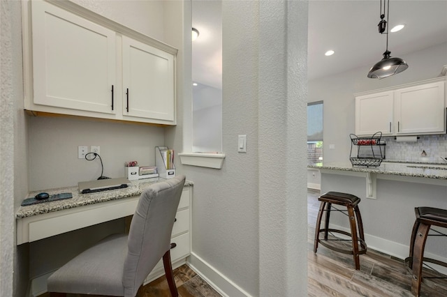 office space featuring built in desk and light hardwood / wood-style flooring