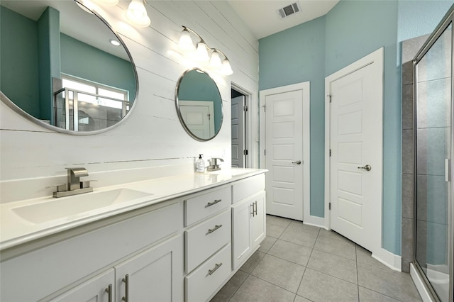 bathroom featuring tile patterned flooring, vanity, and a shower with shower door