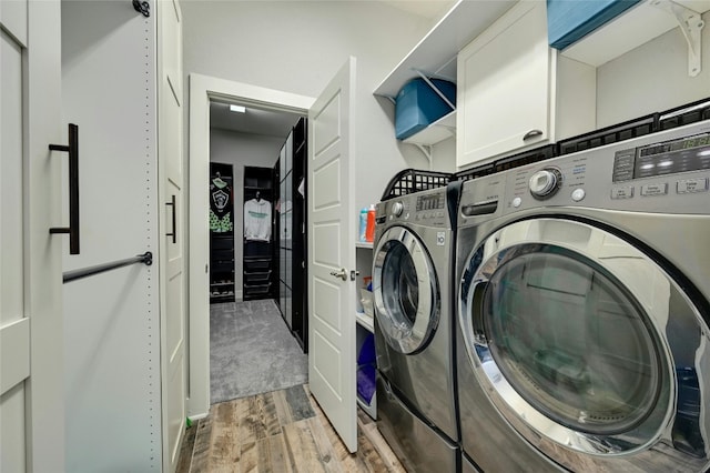 laundry area featuring washer and clothes dryer and wood-type flooring