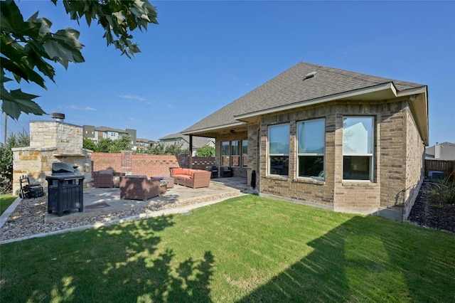 back of house featuring an outdoor living space with a fireplace, a patio, and a lawn