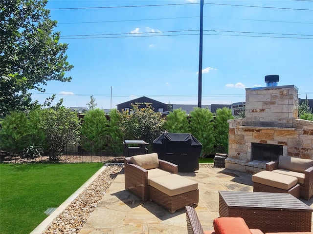 view of patio featuring an outdoor stone fireplace and area for grilling