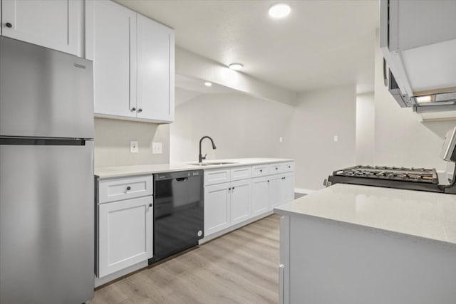 kitchen featuring light hardwood / wood-style flooring, black dishwasher, white cabinets, stainless steel fridge, and sink