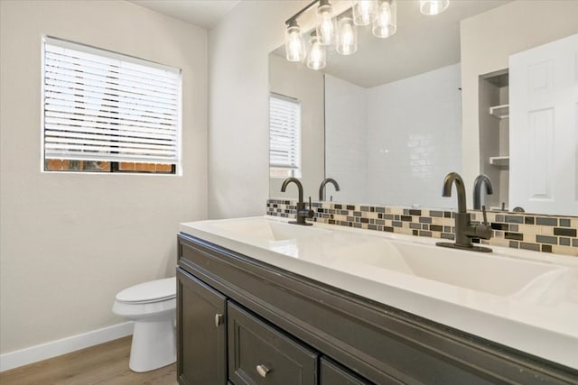 bathroom with backsplash, wood-type flooring, a wealth of natural light, and toilet