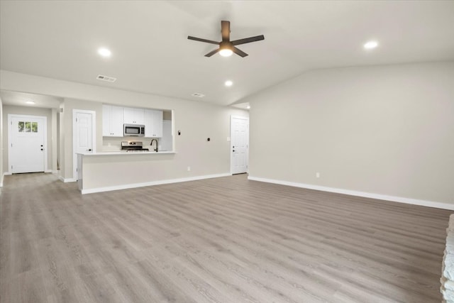 unfurnished living room featuring ceiling fan, light wood-type flooring, and vaulted ceiling