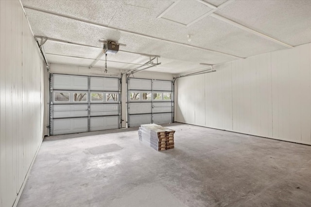 garage featuring wood walls and a garage door opener