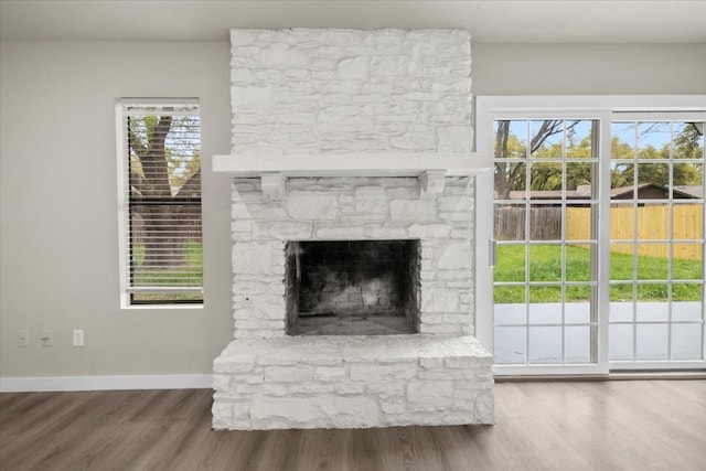 interior details featuring a stone fireplace and hardwood / wood-style floors