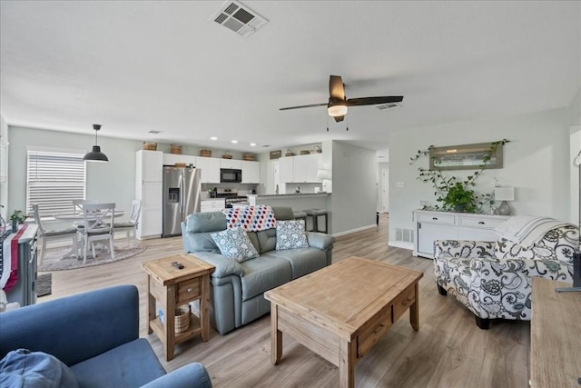 living room featuring ceiling fan and light hardwood / wood-style flooring