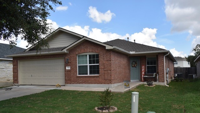 ranch-style house featuring central air condition unit, a front yard, and a garage